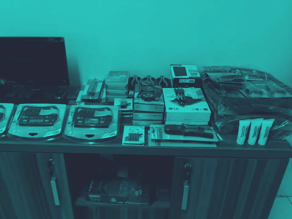 Mesa com material de escritório e equipamentos ainda embalados, no período da troca de nome da empresa
